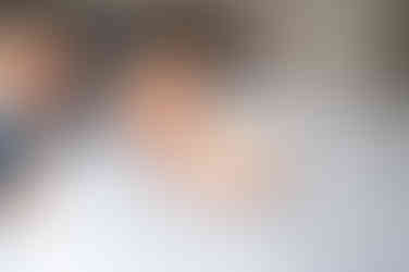 Een fotoshoot op het grote bed van de ouders waarbij de grote broer bij zijn baby zusje komt kijken. 