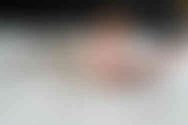 Newborn en grote broer liggen samen op een wit dekbedovertrek. 