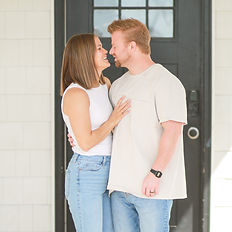 Young couple looking at each other lovingly on their front porch