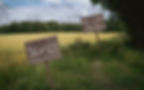 wooden signposts in a field. the first says Your journey starts here, the second has This is how we can help you written on it.