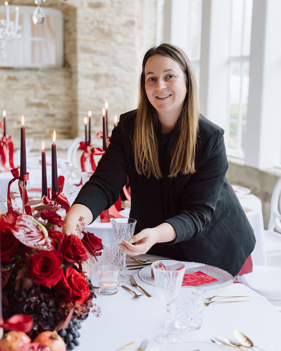 Alina, Floristin von Ivy & Rose aus Barßel, dekoriert eine Hochzeitstafel mit roten Rosen und Kerzen