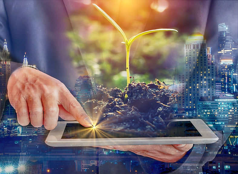 Double Exposure businessman touch screen laptop with young plants growing in polluted city