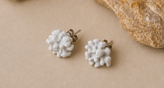 White coral inspired stud earrings displayed with natural stones by Khoraia