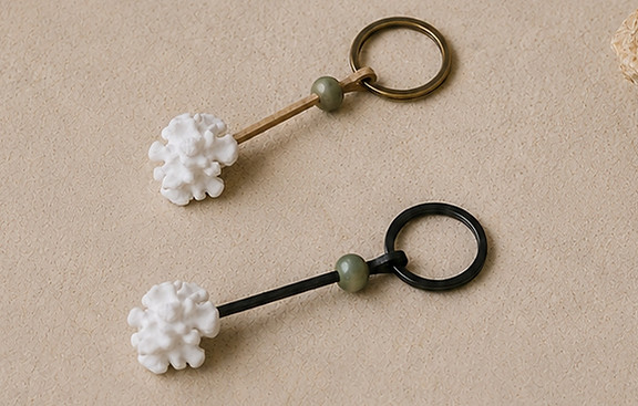 White coral inspired beach keychains displayed with natural stones