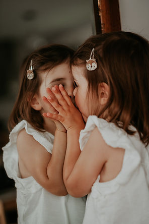 petite fille qui se regarde dans un miroir