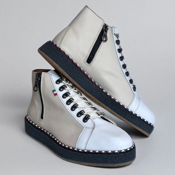 Eye-level view of beige high-top sneakers paired with rolled-up jeans