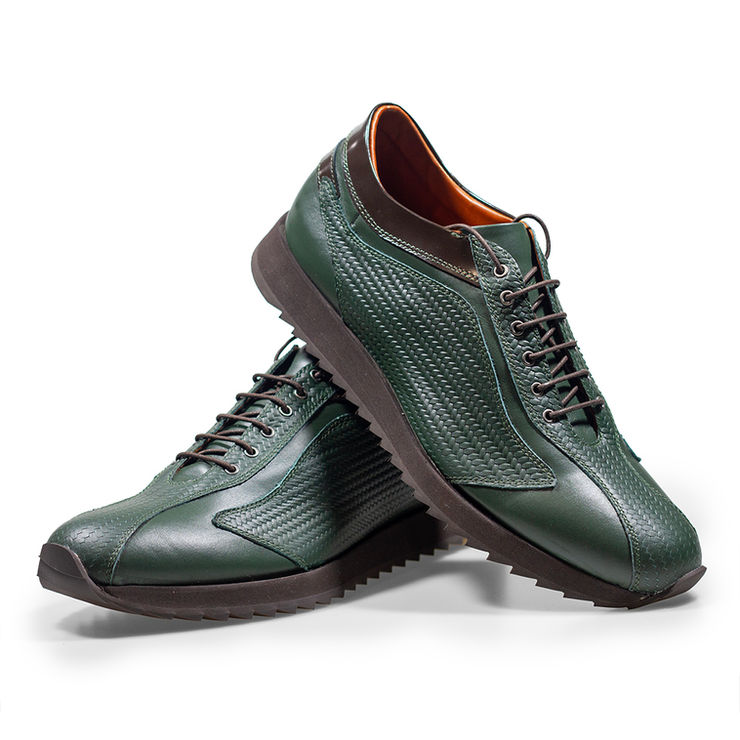 Pair of handcrafted leather oxford shoes on ivory plinth.