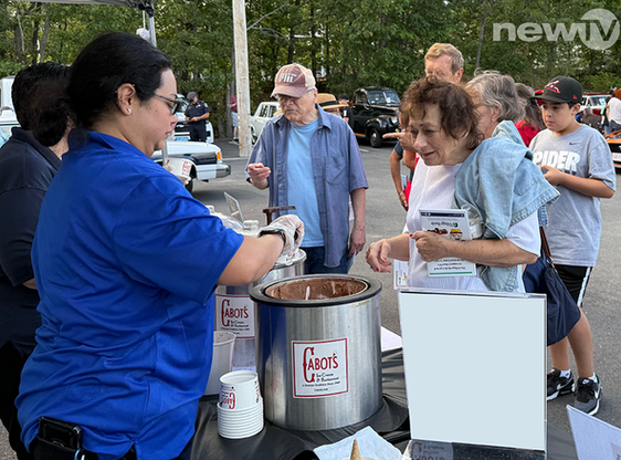 A woman scooping ice cream for an elderly woman.