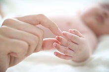 Mère tenant un doigt de bébé
