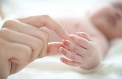 Mère tenant un doigt de bébé