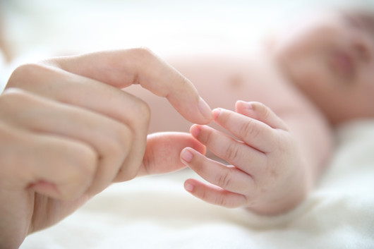Mère tenant un doigt de bébé