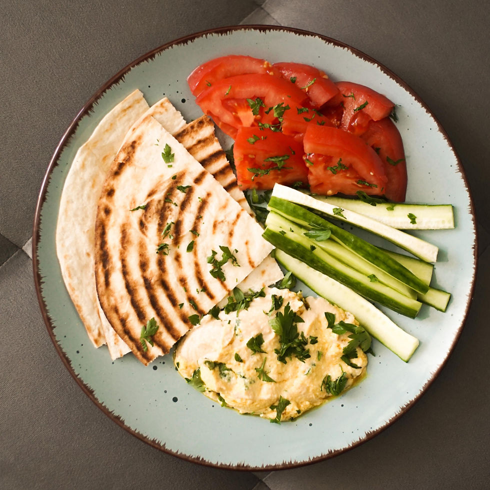 a plate with hummus, pita, and veggies