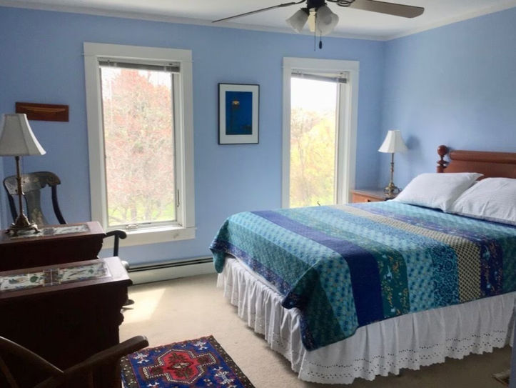 a room with a queen bed and views to the orchard