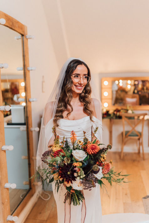 bronzed bridal make up with orange flower bouquet 