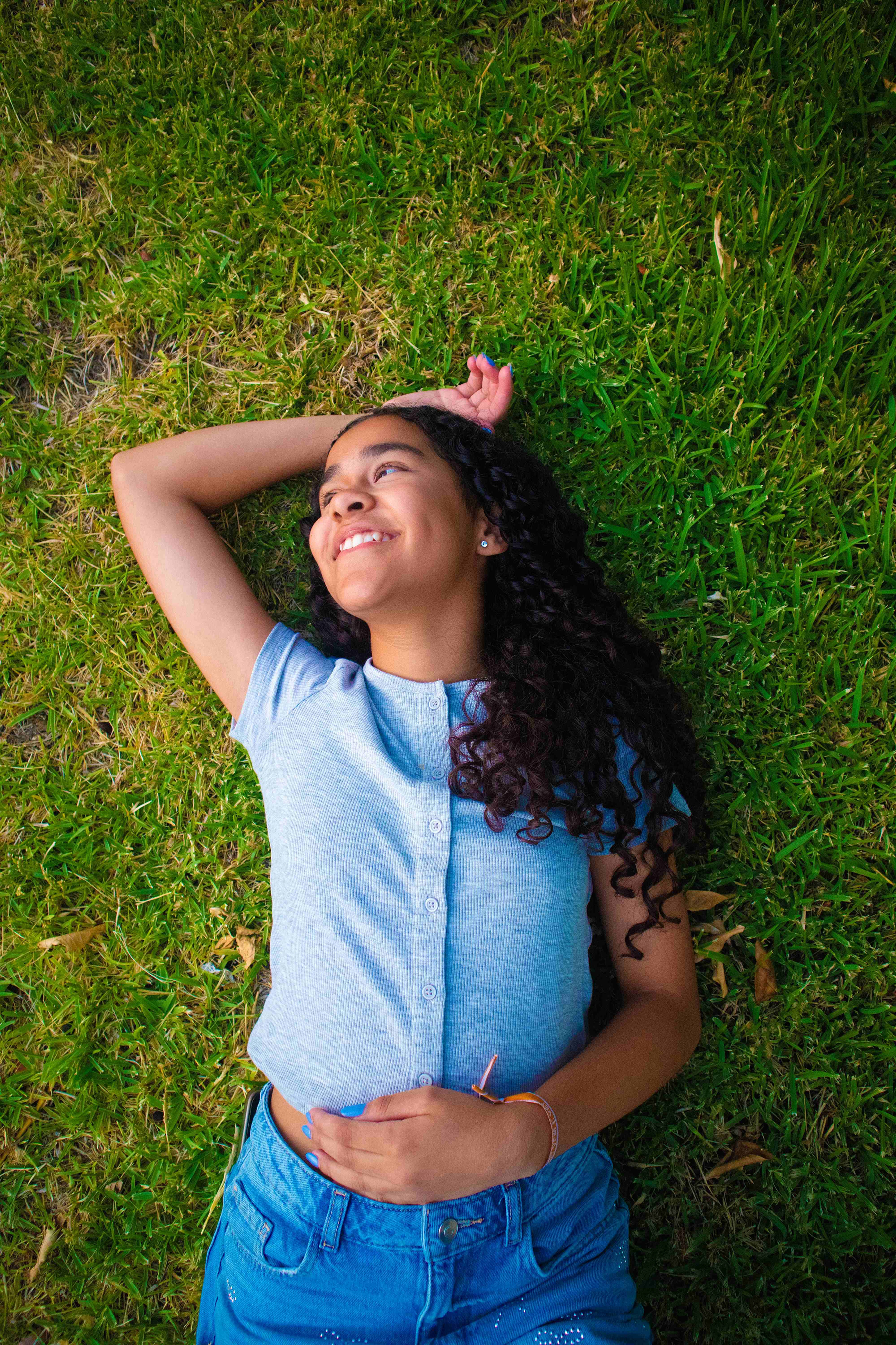 Menina sorridente deitada na relva em Caldelas, Amares.