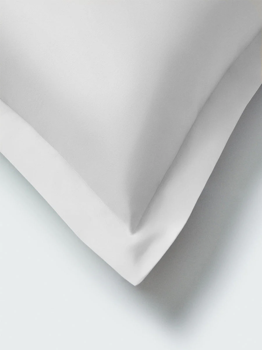 Premium white cotton hotel sheets with a smooth, crisp finish designed for a luxury hotel bedroom experience.