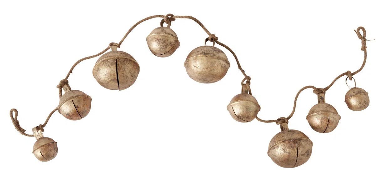 String of rustic metal bells on a curved cord, isolated on a white background.