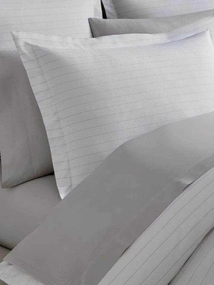 Luxury hotel bedroom featuring the Four Seasons Banyan Duvet Cover Set with soft striped cotton bedding and elegant neutral styling.