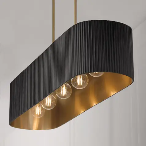 Black and gold linear pendant light featuring a fluted metal shade for kitchen islands, dining rooms, and modern luxury home decor.
