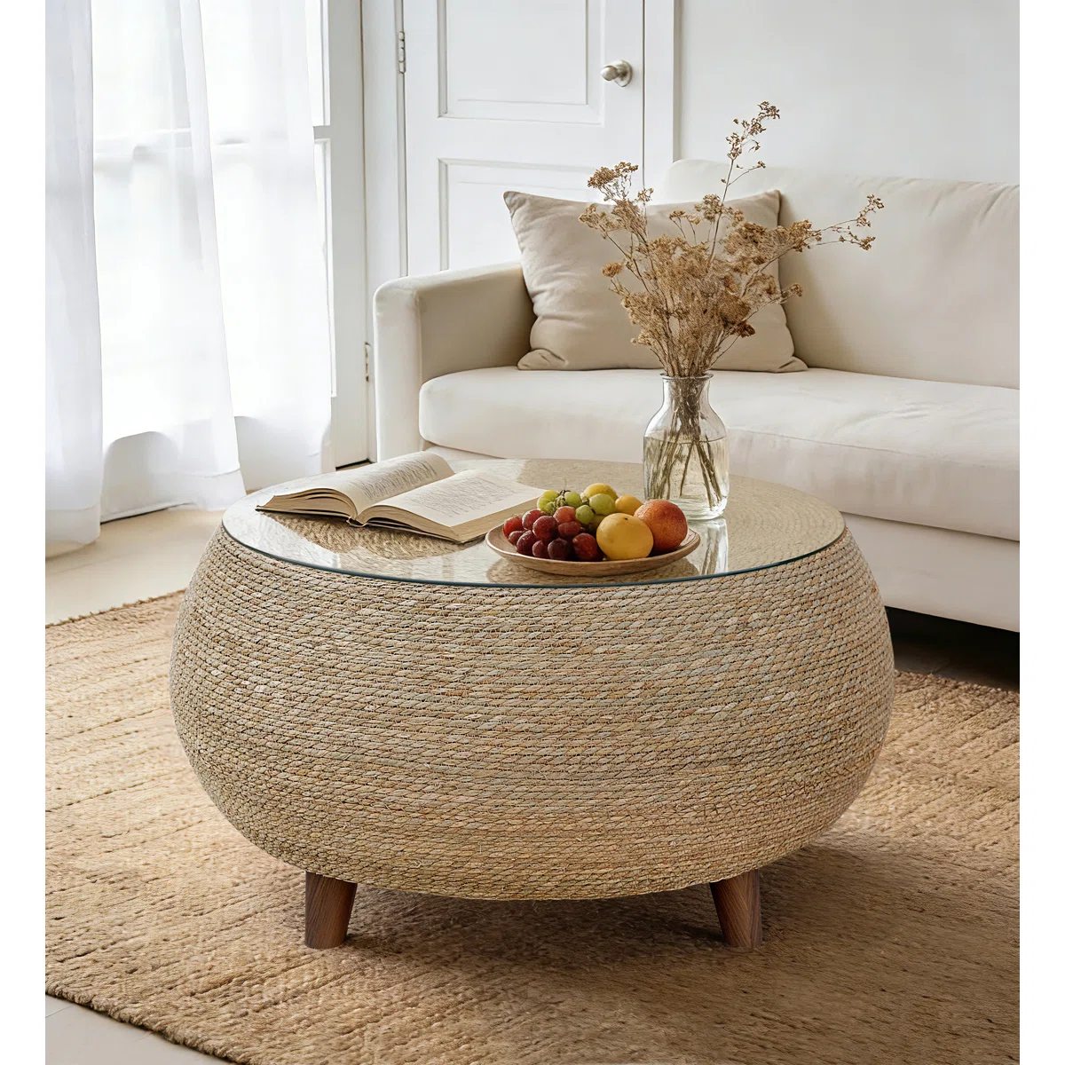 round woven coffee table with glass top in neutral coastal living room