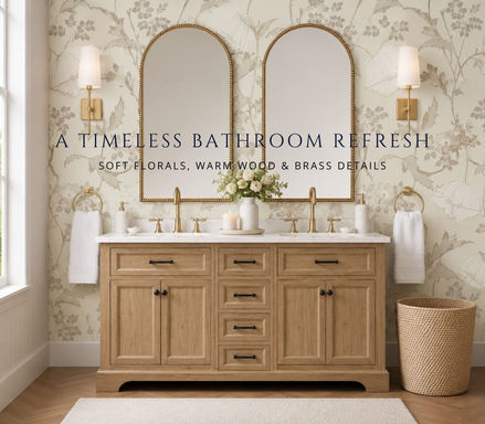 Pottery Barn style bathroom with light wood double vanity, brass mirrors, floral wallpaper and warm neutral decor