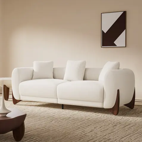 Modern cream bouclé curved sofa with sculptural wood legs for quiet luxury, organic modern, contemporary, and designer living room decor.