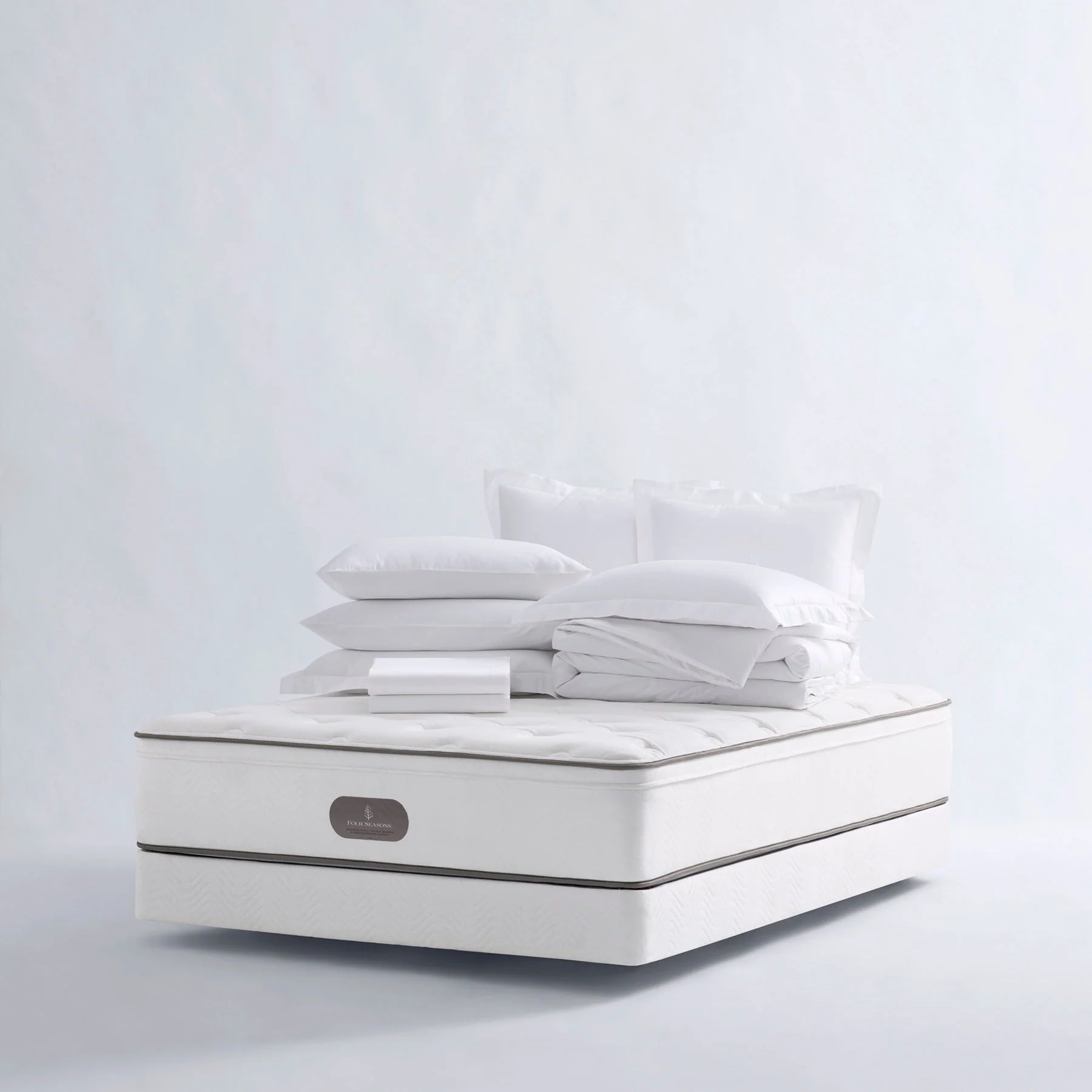 Luxury hotel bedroom featuring the Four Seasons Signature Mattress with plush pillows and premium hotel-quality comfort.