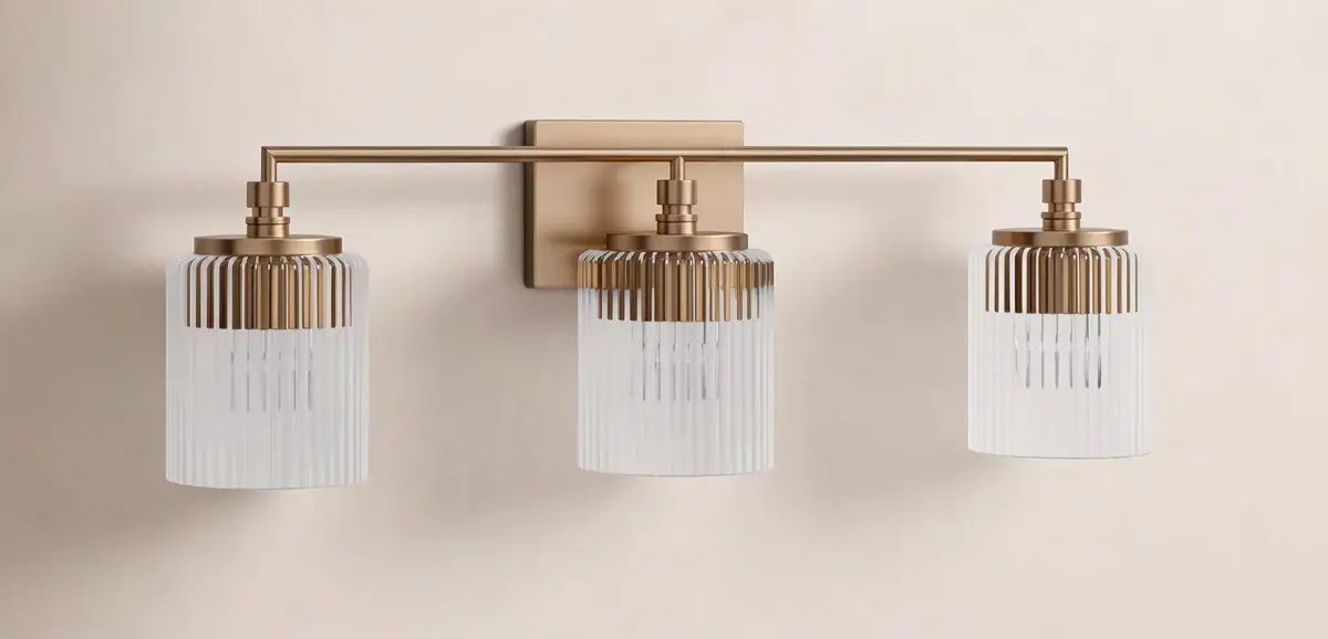 Three-light brass and frosted glass wall sconce on a beige wall