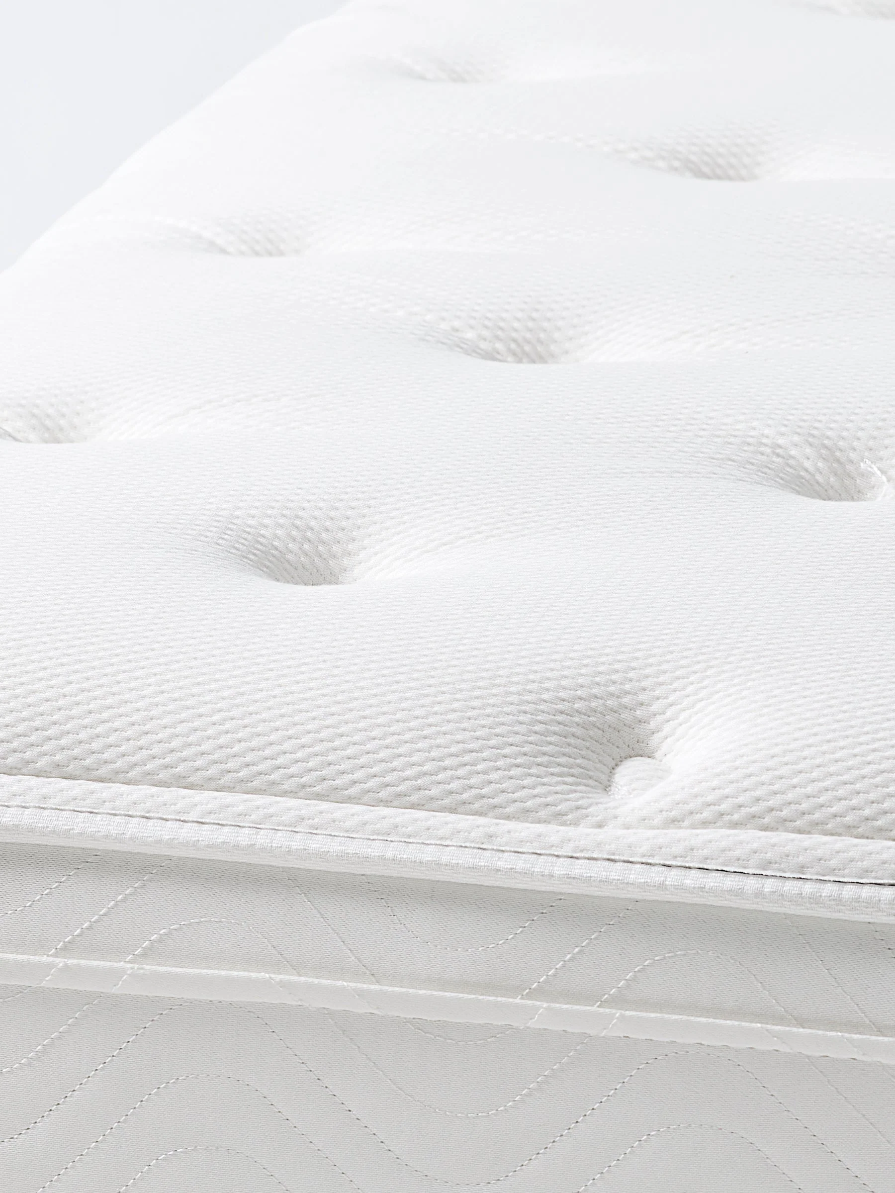 Close-up of the Four Seasons Signature Plush Mattress showcasing its quilted sleep surface for a luxury hotel bedroom experience.