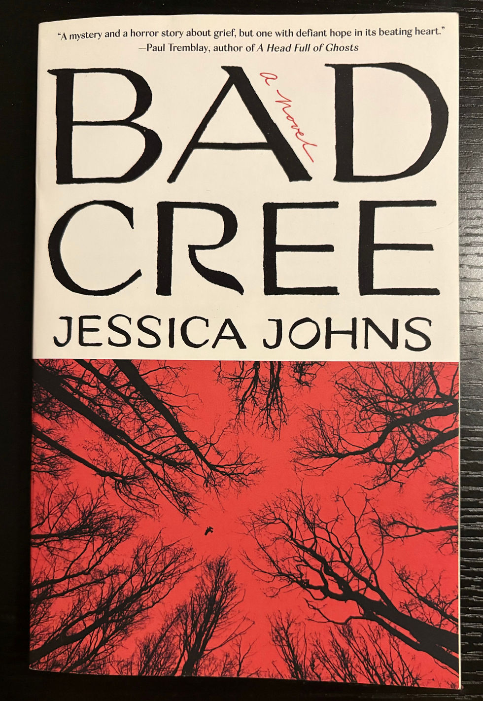 Book cover for Bad Cree by Jessica Johns, with red tree imagery and text.