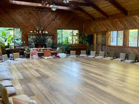 A wood paneled room set up with meditation chairs in a circle