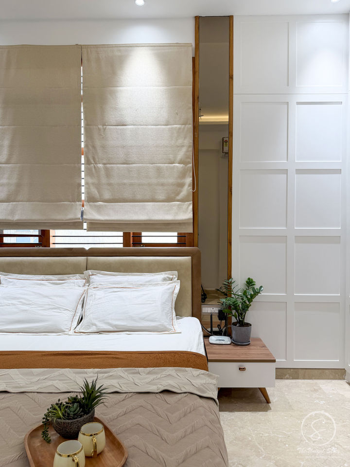 Modern bedroom design India with white wardrobe and beige bed