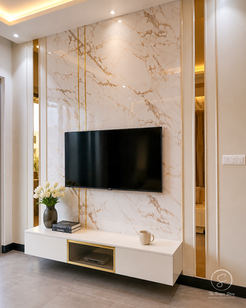 Modern bedroom featuring a wall-mounted TV, marble accent panel, floating media console, ambient lighting, and sophisticated contemporary interior styling