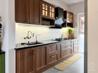 Modern modular kitchen design India with dark wood cabinets and black countertops