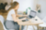 Woman working at a wooden table with a laptop and tablet pen | executive functioning coach for young adults in Boulder County, CO | executive functioning coaching for young adults | executive skills coaching | Superior | Lafayette | North Boulder