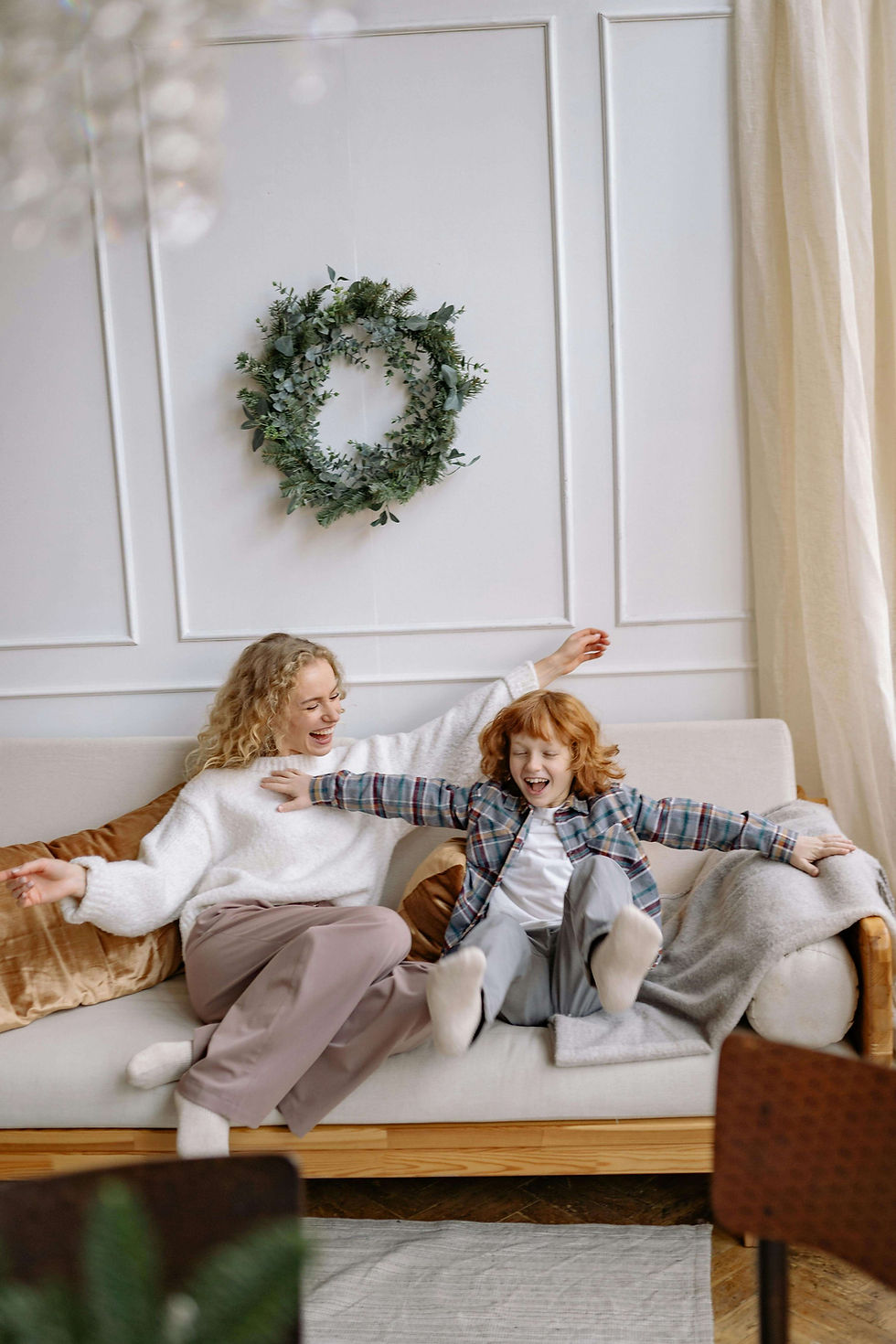 A woman and child joyfully stretch their arms on a cozy sofa | parent coaching in boulder county, co | parent coach | parenting coach online | Boulder | Arapahoe | Foothills