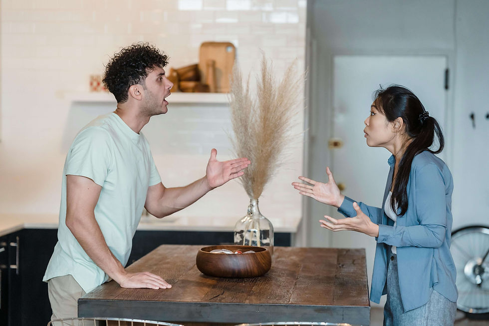 Couple argues across a kitchen table, hands raised in frustration. A seasoned couples therapist in San Diego, CA uses couples and relationship therapy or online couples therapy in California to calm conflict and teach repair skills.