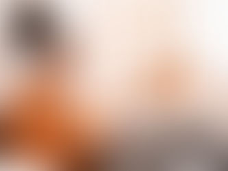 A young woman smiles while using a laptop with headphones on, comfortably settled at home — reflecting the accessible, welcoming nature of online ketamine therapy in Colorado. For those exploring ketamine-assisted therapy in Colorado, the process often begins with exactly this kind of relaxed, at-home telehealth experience. Compass Healing Project makes it easy to take that first step toward healing from wherever you are in the state.