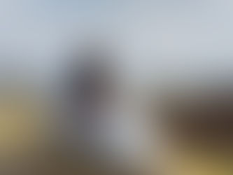 A couple sits on a grassy dune overlooking the ocean, embracing their newborn together, symbolizing connection and healing—reflecting dad therapy in Des Plaines, IL and support from a postpartum therapist in Des Plaines, IL for parents rebuilding intimacy and emotional closeness after childbirth. Des Plaines, IL | Lincoln Park, IL | Cumberland, IL