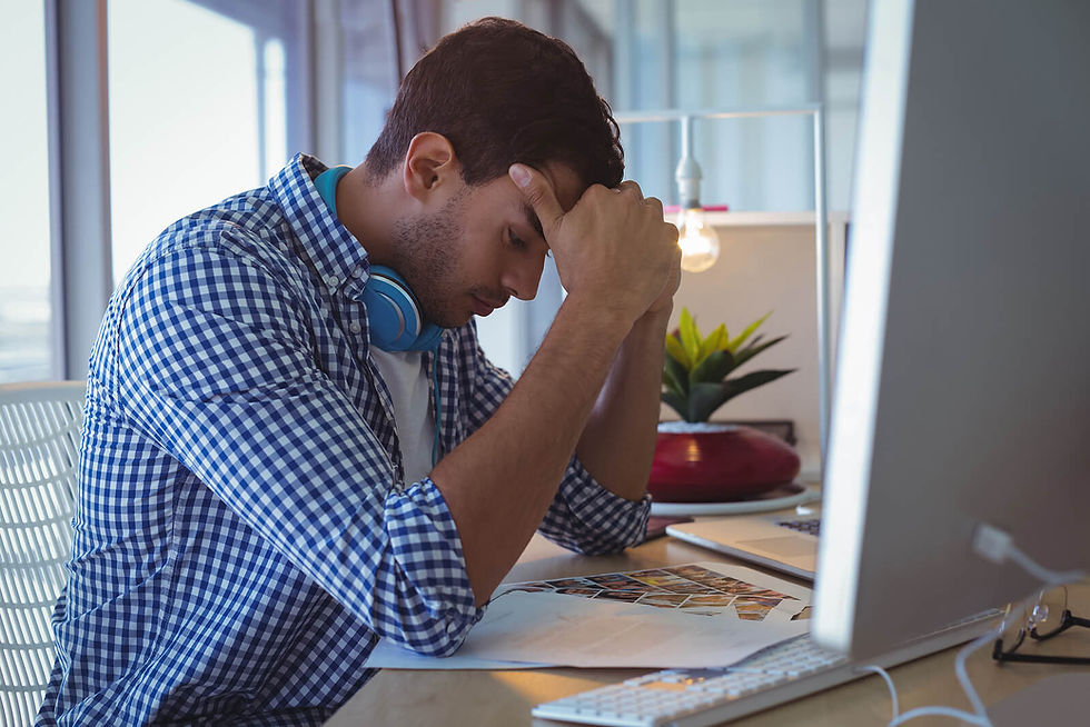 A young man sitting at his office desk with his head in his hands, appearing mentally exhausted and overwhelmed. This moment of quiet collapse is something burnout treatment in Denver, CO is designed to address. Understanding the difference between anxiety and stress in Colorado is an important first step toward getting the right support.
