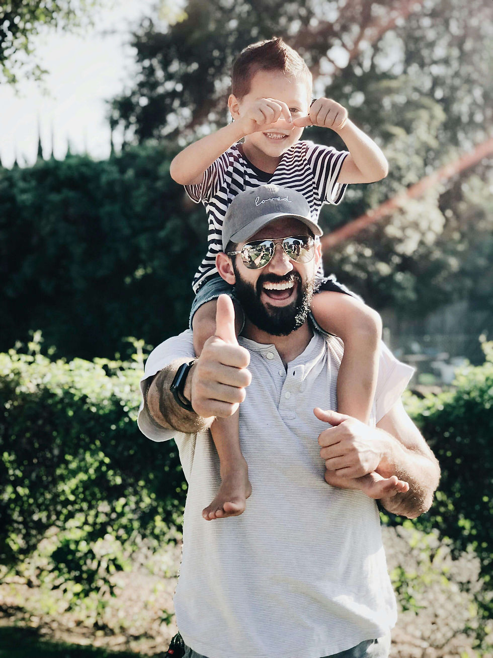 A joyful father carries his child on his shoulders outdoors, symbolizing healing and resilience through EMDR therapy in Des Plaines, IL for male postpartum in Des Plaines, IL. Des Plaines, IL | Cumberland, IL | Craig Manor, IL