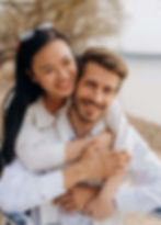 Smiling couple hugging on a beach, with the woman piggybacking the man | dating anxiety in Manhattan, NY | anxiety therapy | therapist for anxiety | Upper West Side | Upper East Side | Financial District