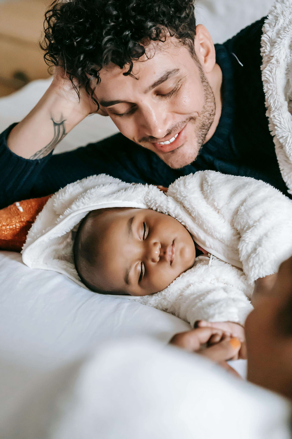 A tender moment between a parent and their sleeping baby, symbolizing the importance of therapy for dads in Des Plaines, IL, and support for postnatal depression in men in Des Plaines, IL. Golf Terrace, IL | Park Ridge, IL | Arlington Heights, IL