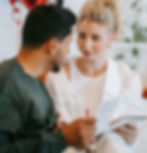 A man and woman sit closely, sharing a notebook and pen, engaging in a warm conversation | anxiety therapy in Manhattan, NY | intimacy anxiety | therapist for anxiety | Upper West Side | Upper East Side | Financial District