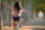 Image of a happy young adult woman riding a bike through a city park with her arms stretched out | young adult therapy in manhattan, ny | young adult therapist in manhattan, ny | burnout in manhattan, ny | young adult anxiety | young adults counseling | 11050 | 10583 | 10010