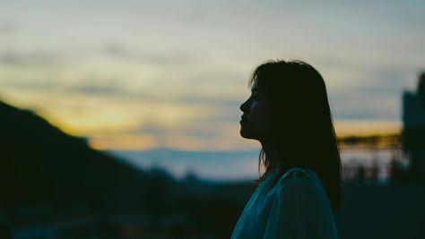 Silhouette of a woman in side profile outdoors looking thoughtful, representing identity exploration supported through immigrant therapy in NYC | immigrant therapy nyc - immigrant grief therapy nyc - south asian therapist nyc