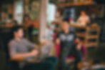 Two men engaged in a lively conversation in a modern cafe setting, symbolizing the importance of addressing male PPD in Des Plaines, IL, with the support of a postpartum therapist in Des Plaines, IL. Northwest Des Plaines, IL | Cumberland Highlands, IL | Park Ridge, IL