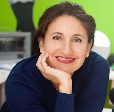 A woman with her hand under her chin smiling.