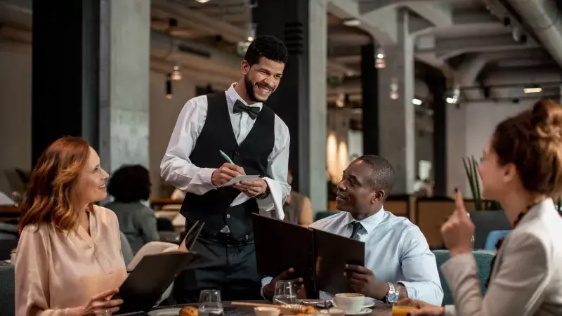 server taking orders at a hotel restaurant.jpg.webp