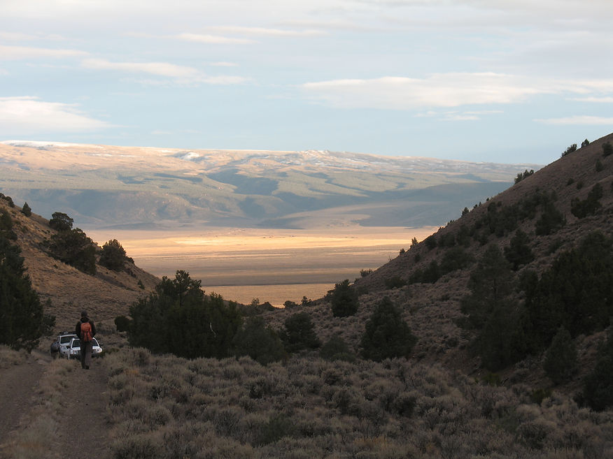 Cyclist on a dirt path overlooking a wide valley